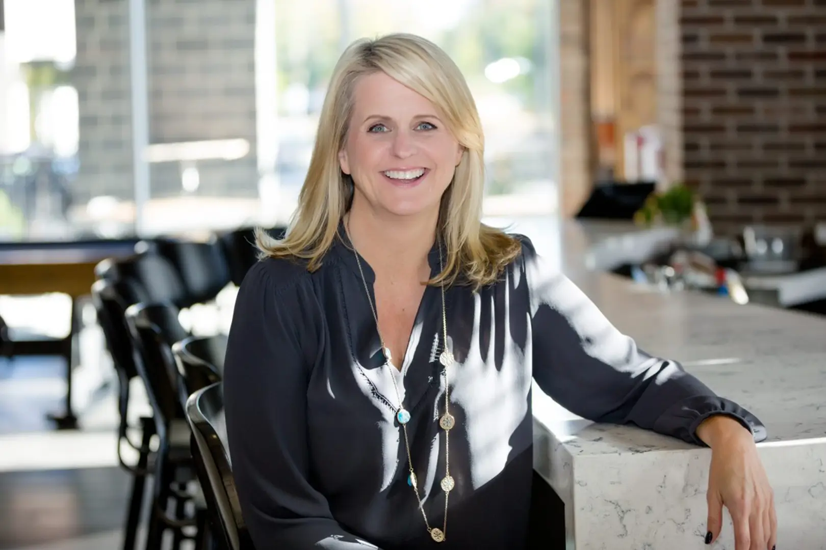 A woman sitting in front of some chairs