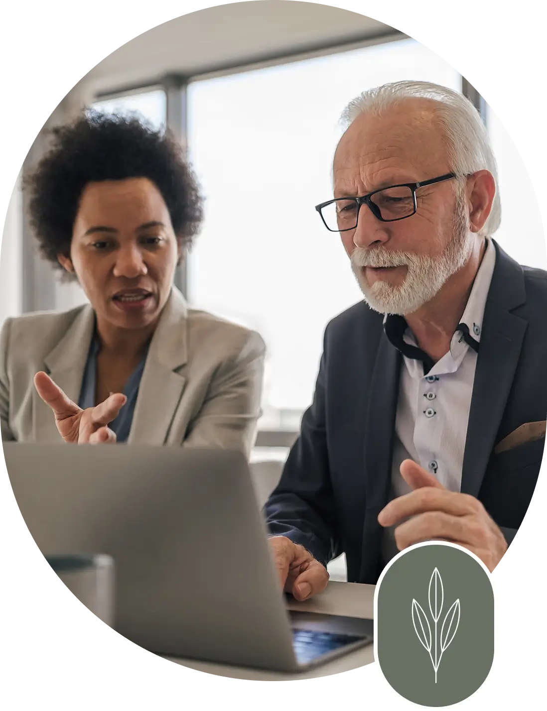 A man and woman looking at a laptop.